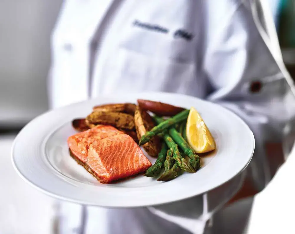 Hawthorn Senior Living Chef Created Meals, chef delivering a finished dish.