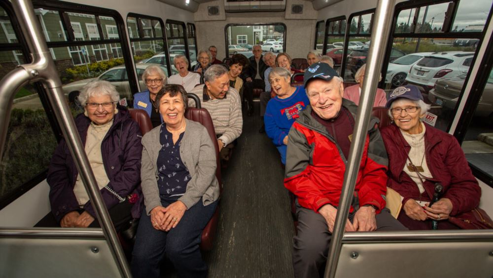 The Carriage House happy seniors on a bus.